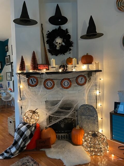 fire mantel decorated for Halloween with Goodwill items
