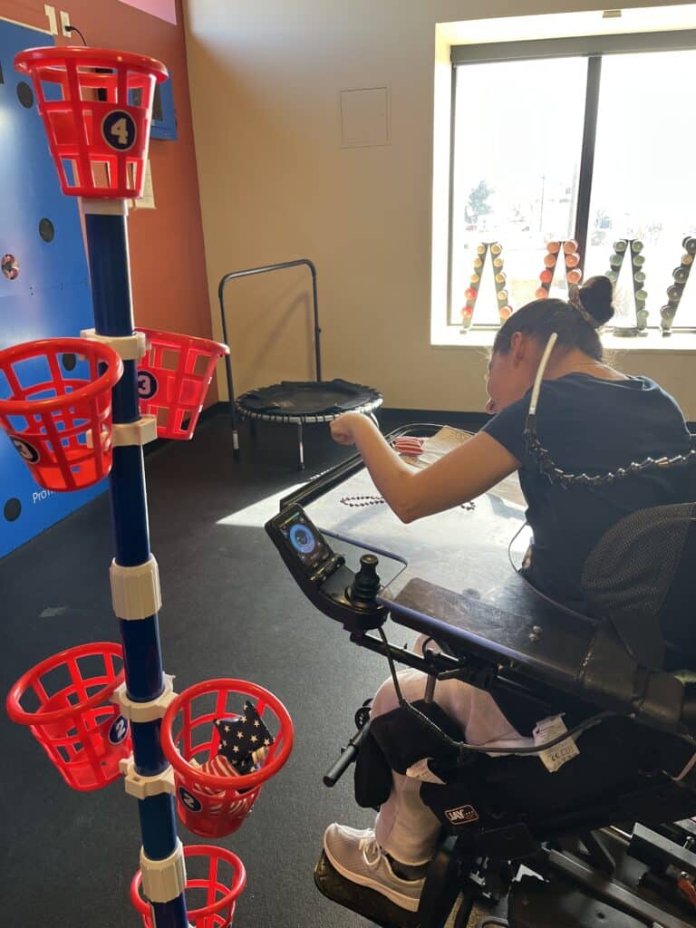Young woman tosses items into basket game.